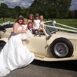 Brides poses with wedding vehicle in Bury, Lancs